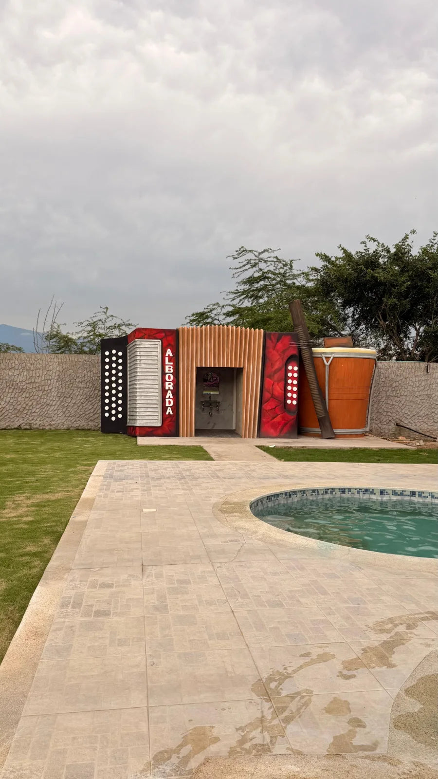 Estructura decorativa de acordeón y tambor junto al borde de la piscina de La Alborada.